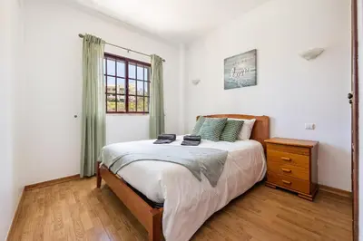 a bedroom with a large bed and a window at Villa Krishan Albufeira - Private Pool in Albufeira