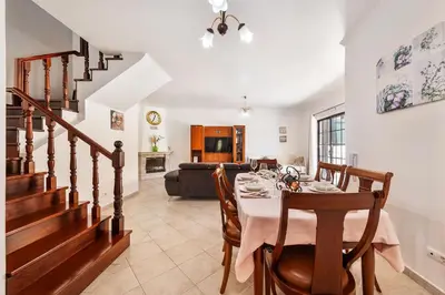a dining room with a table and a couch at Villa Krishan Albufeira - Private Pool in Albufeira