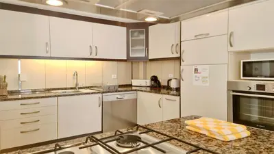 a kitchen with white cabinets and a counter top at Marina parque CD 68 - Cleverdetails - private pool, few steps to the marina in Vilamoura