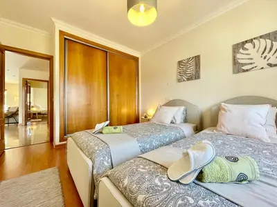 two beds sitting next to each other in a room at Casa Falésia - 150 meters from Falésia Beach in Albufeira