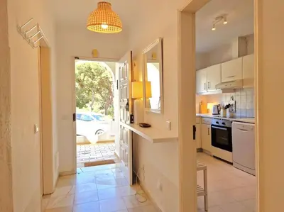 a kitchen with white appliances and a door to a yard at Ancão beach duplex with private garden in Almancil