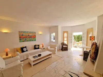 a living room with a couch and a table at Ancão beach duplex with private garden in Almancil