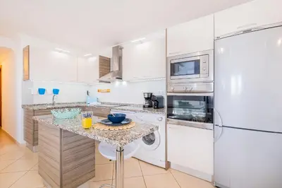 a kitchen with a counter with a washer and dryer at Daisy 2 Bedroom Apartment in Albufeira