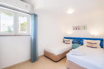 two beds in a room with a window at Daisy 2 Bedroom Apartment in Albufeira