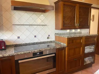 a kitchen with wooden cabinets and a stove top oven at AL Monte Lusitano in Loulé