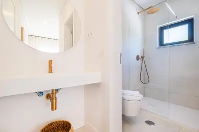 a white bathroom with a sink and a mirror at Valbom Luxury Village in Galé