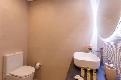 a bathroom with a white toilet and a sink at Villa Golden Falésia by HelloVacations in Albufeira