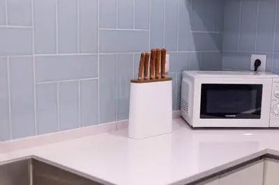 a kitchen counter with a microwave and a container of wooden sticks at Villa Golden Falésia by HelloVacations in Albufeira