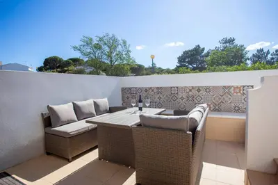 a patio with a table and chairs on a balcony at Villa Golden Falésia by HelloVacations in Albufeira
