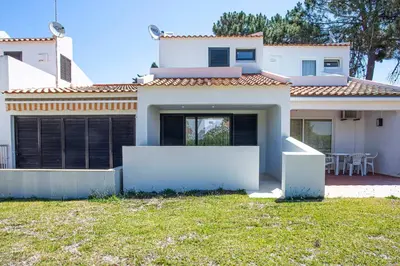 a white house with a lawn in front of it at Villa Serenity Falésia by HelloVacations in Albufeira