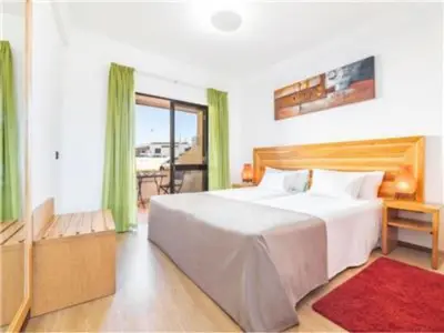 a bedroom with a large white bed and a balcony at Perfect ApartHotel 1 Bedroom in Olhos de Água