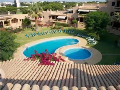 a view of a swimming pool with chairs and a building at Perfect ApartHotel 1 Bedroom in Olhos de Água