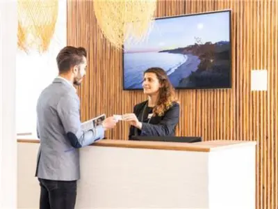 a man and a woman standing at a counter at Perfect ApartHotel 1 Bedroom in Olhos de Água