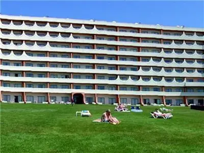 a large building with people laying on the grass in front of it at Exciting Albufeira Studio in Albufeira