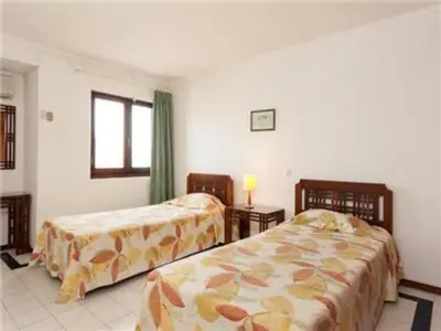 a bedroom with two beds and a window at Superb Apartments 2 Bedroom in Olhos de Água