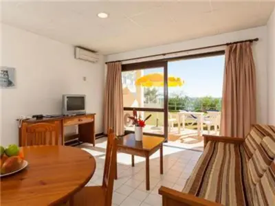 a living room with a table and a room with a patio at Superb Apartments 2 Bedroom in Olhos de Água
