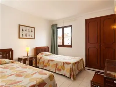 a hotel room with two beds and a window at Superb Apartments 2 Bedroom in Olhos de Água