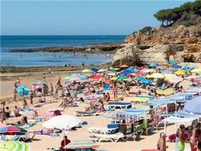 a crowd of people on a beach with umbrellas at Superb Apartments 2 Bedroom in Olhos de Água