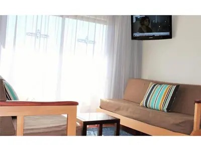 a living room with a couch and a tv on the wall at Spectacular Albufeira 2 Bedroom apartment in the city center in Albufeira