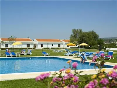 a large swimming pool with chairs and umbrellas at Brilliant Apartments 1 Beedroom in Quarteira