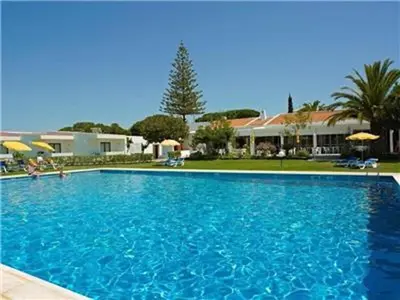 a large blue swimming pool in front of a house at Brilliant Apartments 1 Beedroom in Quarteira
