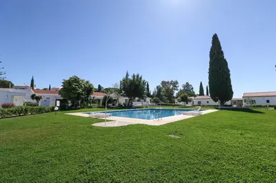 a large yard with a swimming pool in a park at Brilliant Apartments 1 Beedroom in Quarteira