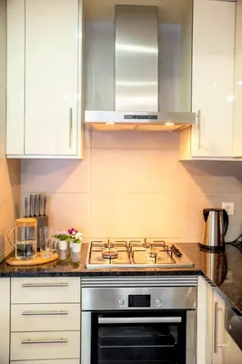 a stove top oven in a kitchen with white cabinets at Beach Side Apartment in Albufeira