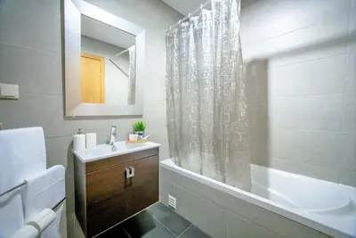 a bathroom with a sink and a tub and a mirror at Beach Side Apartment in Albufeira