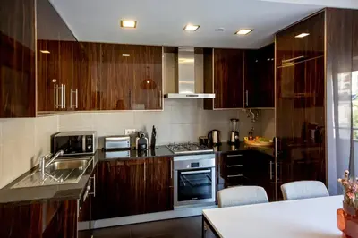 a kitchen with wooden cabinets and a stove top oven at Sun & salt Apartment in Albufeira