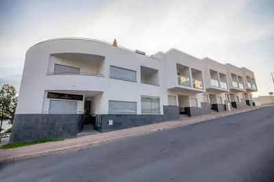 a white building on the side of a street at Sun & salt Apartment in Albufeira