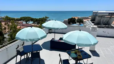 two blue chairs and umbrellas on a balcony with the ocean at Sun & salt Apartment in Albufeira