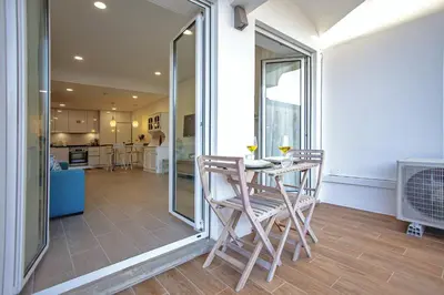 a dining room with a table and chairs and a kitchen at Apartment Sandi in Albufeira
