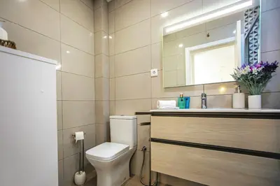 a bathroom with a toilet and a sink and a mirror at Apartment Sandi in Albufeira