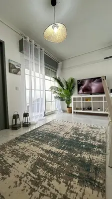 a living room with a large rug and a tv at La vie simple appartement in Albufeira