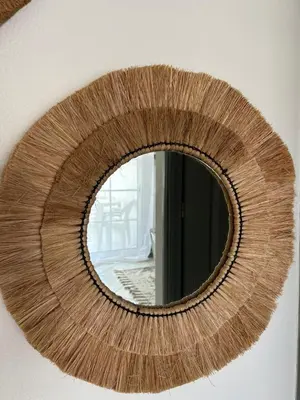 a round mirror on a wall with a wooden at La vie simple appartement in Albufeira