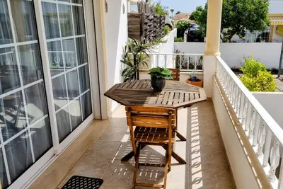 a wooden table on the balcony of a house at Casa ARRIFES in Albufeira