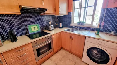 a kitchen with a washing machine and a sink at Casa ARRIFES in Albufeira