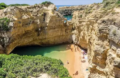 a group of people on a beach in a cave at Casa ARRIFES in Albufeira