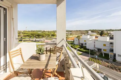 a balcony with a table and chairs and a view of a city at TAC - Bliss Vilamoura in Quarteira