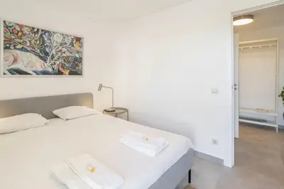 a bedroom with a white bed with two towels on it at TAC - Bliss Vilamoura in Quarteira