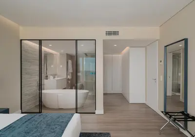 a bedroom with a tub and a large bathroom at Dom Pedro Residences in Vilamoura