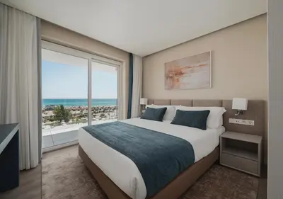 a bedroom with a large bed and a large window at Dom Pedro Residences in Vilamoura