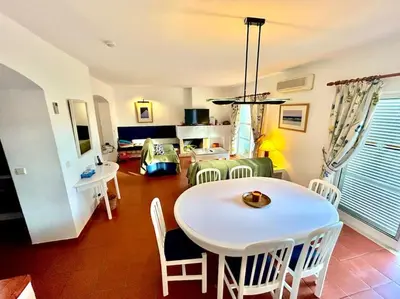 a living room with a white table and chairs at Heart of Quinta do Lago ! in Faro