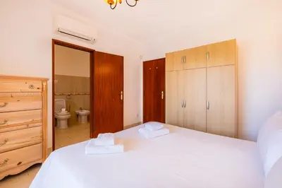 a bedroom with two white beds and a bathroom at Villa Brid in Albufeira