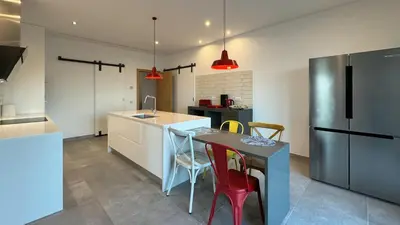 a kitchen with a table and chairs and a refrigerator at Casa da Cotovia, Loule in Loulé