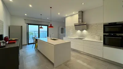 a kitchen with white cabinets and a kitchen island at Casa da Cotovia, Loule in Loulé