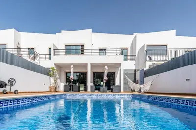 a villa with a swimming pool in front of a building at Villa Feliz Algarve with Private Pool - São Rafael in Albufeira