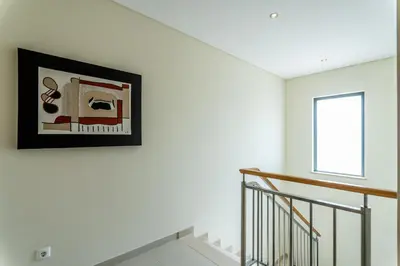 a white staircase with a picture on the wall at Villa Feliz Algarve with Private Pool - São Rafael in Albufeira
