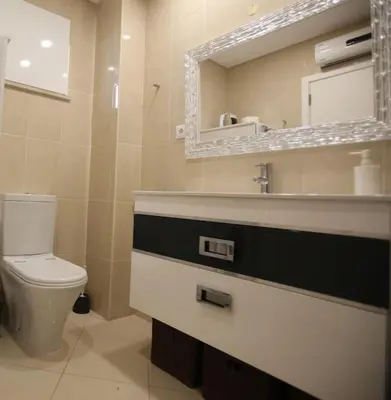 a bathroom with a toilet and a sink and a mirror at Atlantic Pearl by the Sea - Quarteira in Quarteira