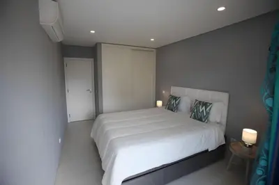 a bedroom with a large white bed with two pillows at Atlantic Pearl by the Sea - Quarteira in Quarteira